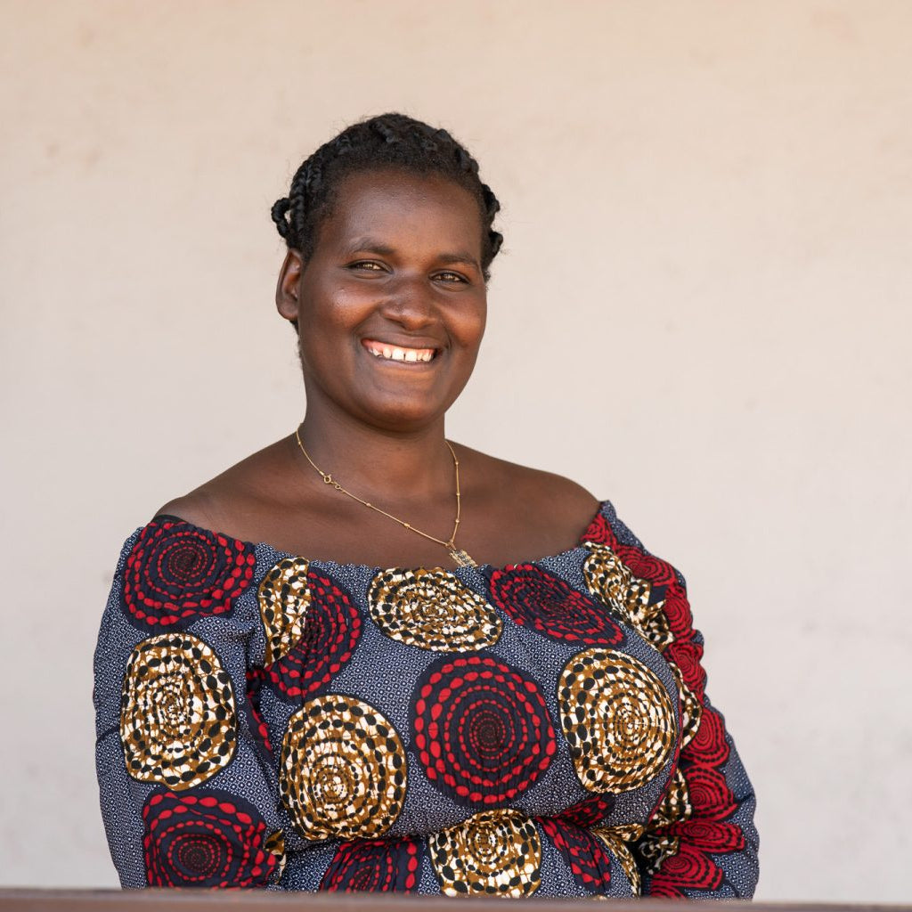 Woman wearing a colorful traditional outfit with a neutral background