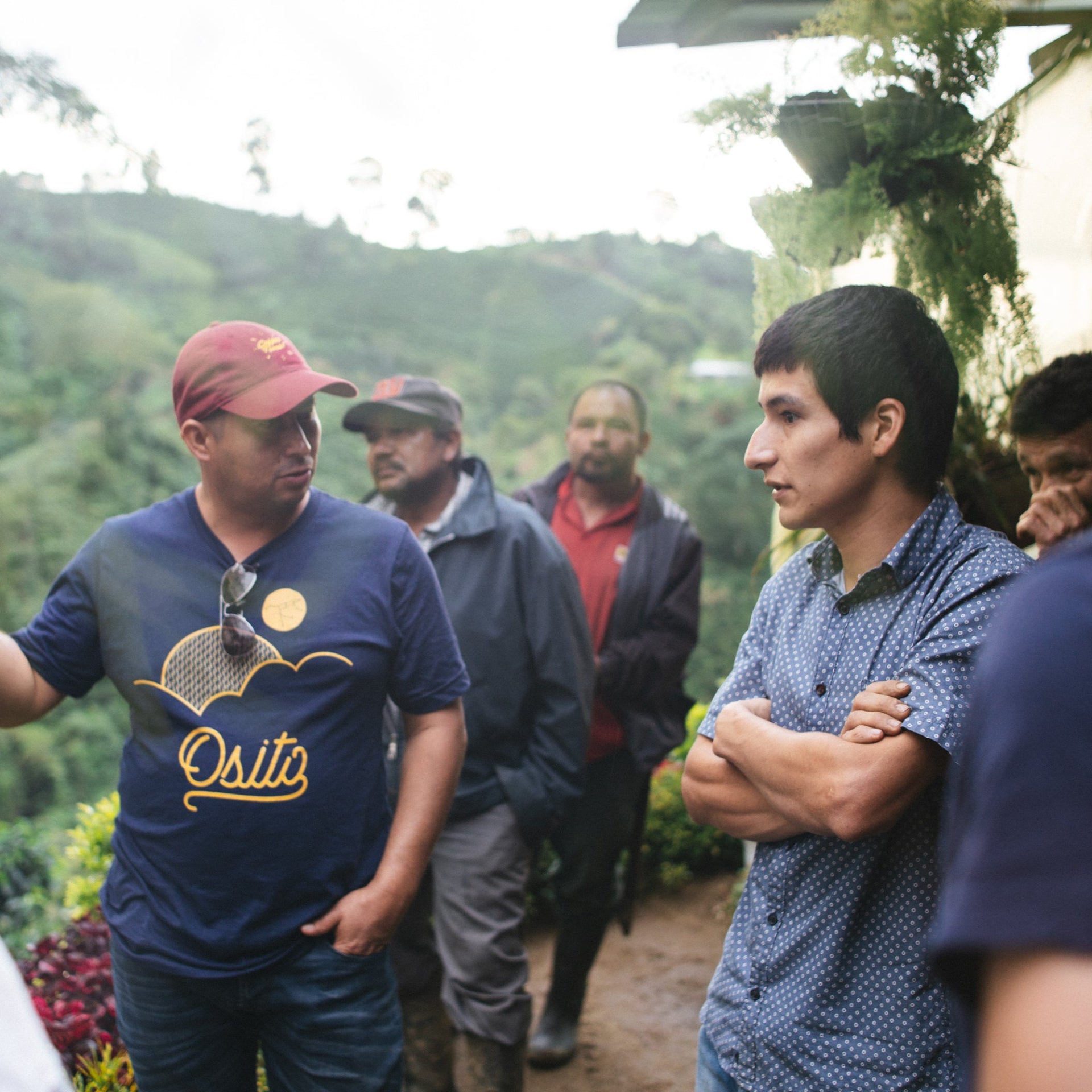 Group of people in a forested area with one person gesturing